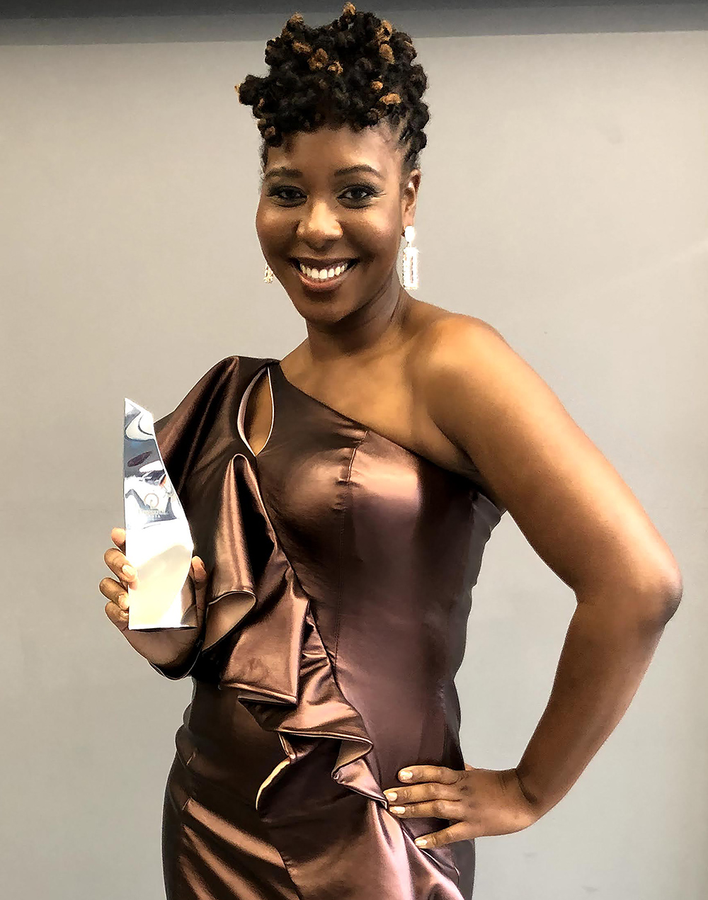 Medina King posing with her Herman Miller Design and Innovation Award at the Powerlist Black Excellence Award