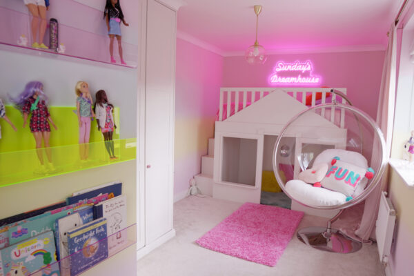 House bed with a pink neon sign above, saying Sundays Dreamhouse - Babrie dolls are displayed on live edged acrylic ledges
